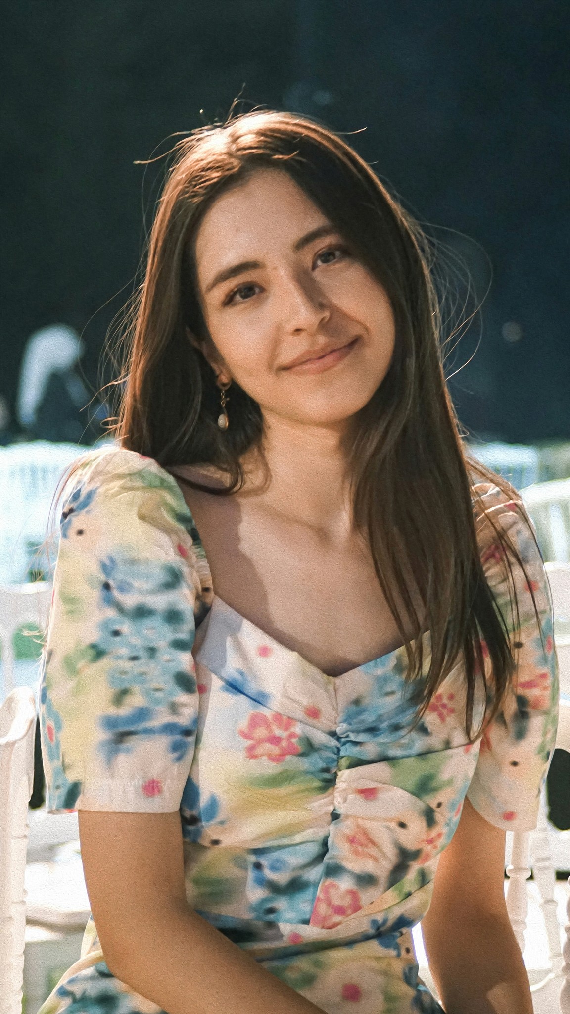 a woman sitting on a white chair next to a table